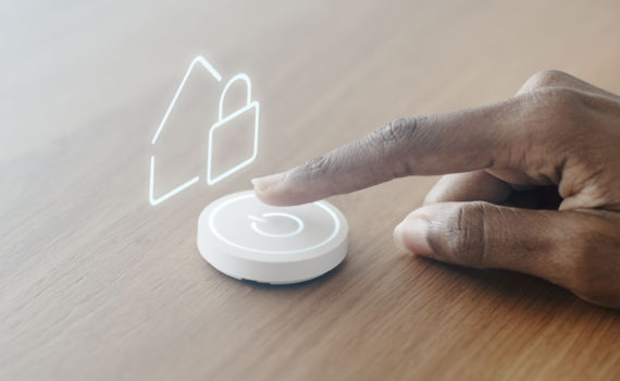 dedo sobre moderno botão que representa "ligar" a casa inteligente
