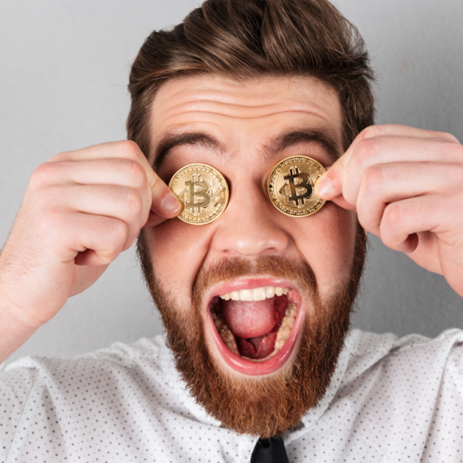 Jovem segura duas moedas de ouro que representam a criptomoeda Bitcoin na altura dos olhos enquanto mostra uma expressão de êxtase