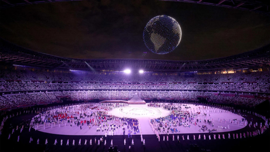 cerimônia de abertura das Olimpíadas 2020 no estádio Olímpico de Tóquio. Centenas de drones formam no céu uma imagem 3D da Terra.