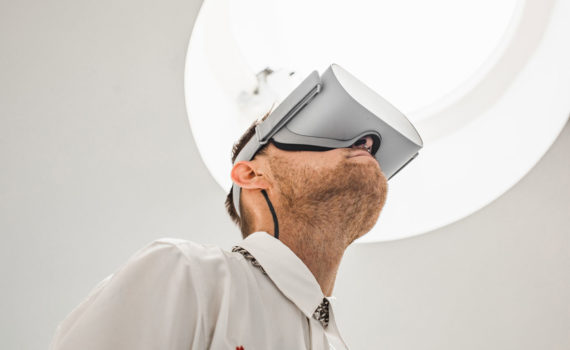 Médico de jaleco veste óculos de realidade virtual em ambiente hospitalar. Google e demais big techs querem dominar a indústria da saúde.